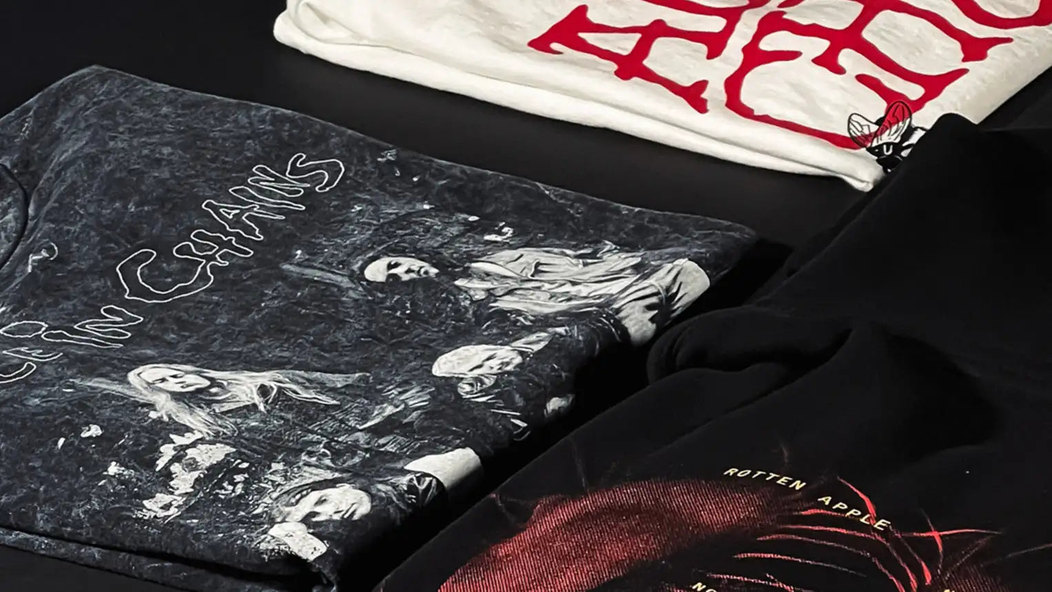 Black graphic tee with white line-art illustration of a band and the text ’betty chains’ printed across it.
